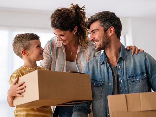 Family of three unpacks boxes in new home