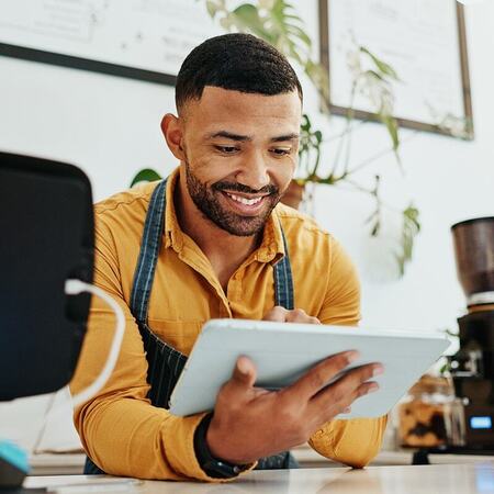 Barista using a cafe tablet to process customer orders